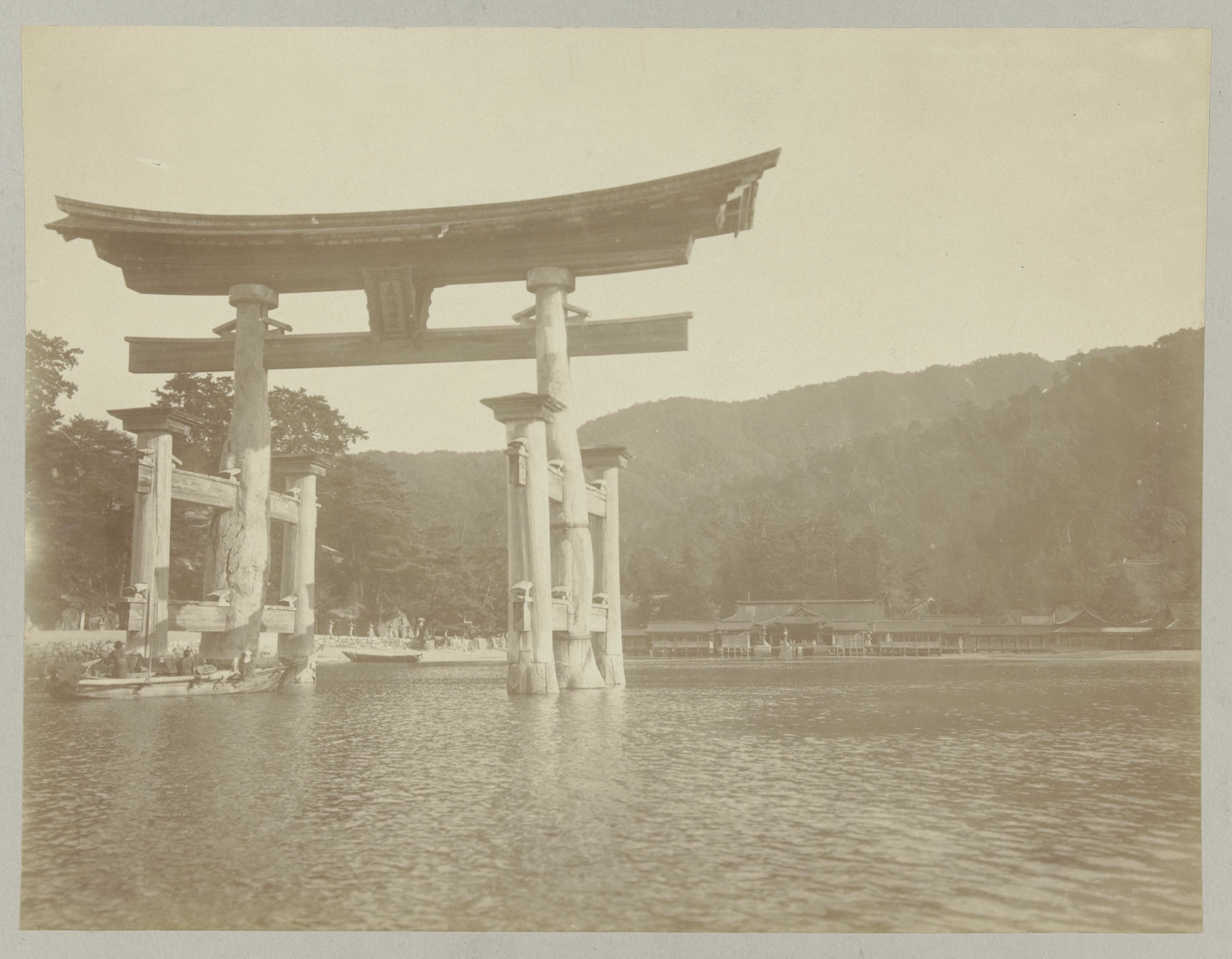 A sepia photograph from about 1900 of the great torii gate of Itsukushima standing in the sea off Miyajima.